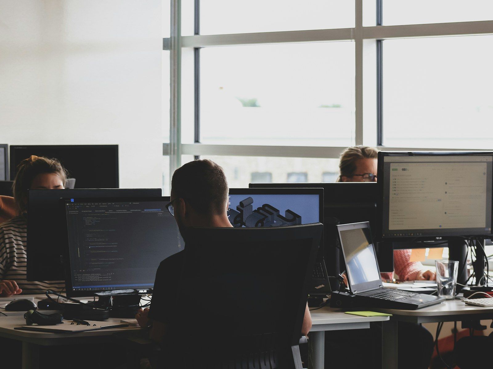 Ops Hub dispatchers at a row of multi-monitor workstations watching live driver routes